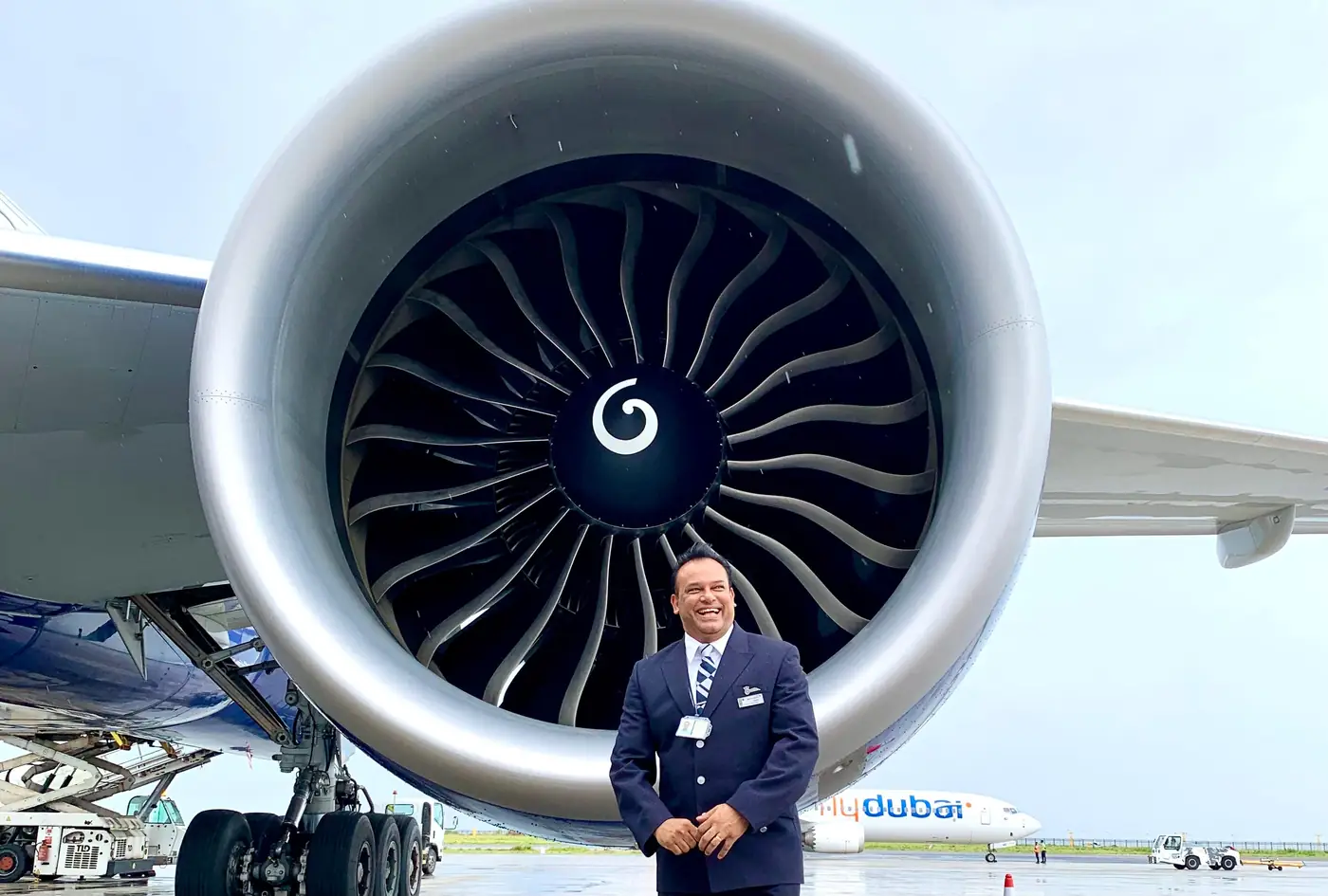 Sabbir Karim in British Airways uniform standing beneath an aircraft engine