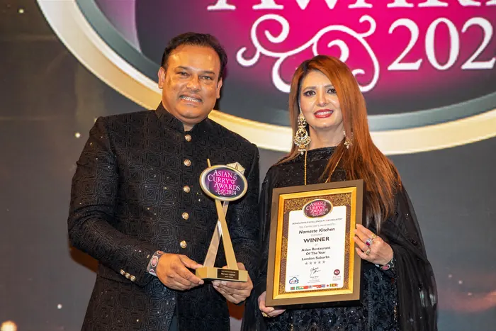 Sabbir Karim holding a trophy and certificate at the Asian Curry Awards 2024