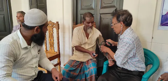 An elderly man having his blood pressure taken at a free clinic
