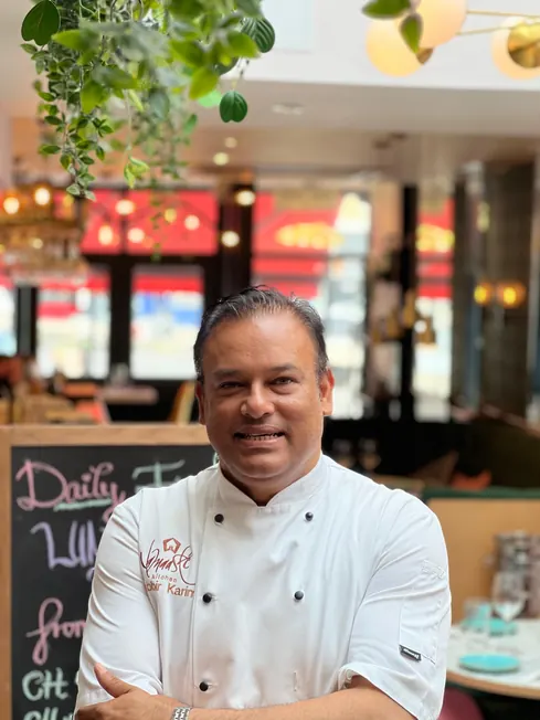 Sabbir Karim in chef whites, arms folded, inside the restaurant