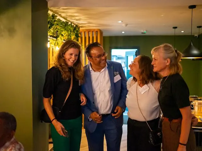 Sabbir Karim laughing with guests at an evening event